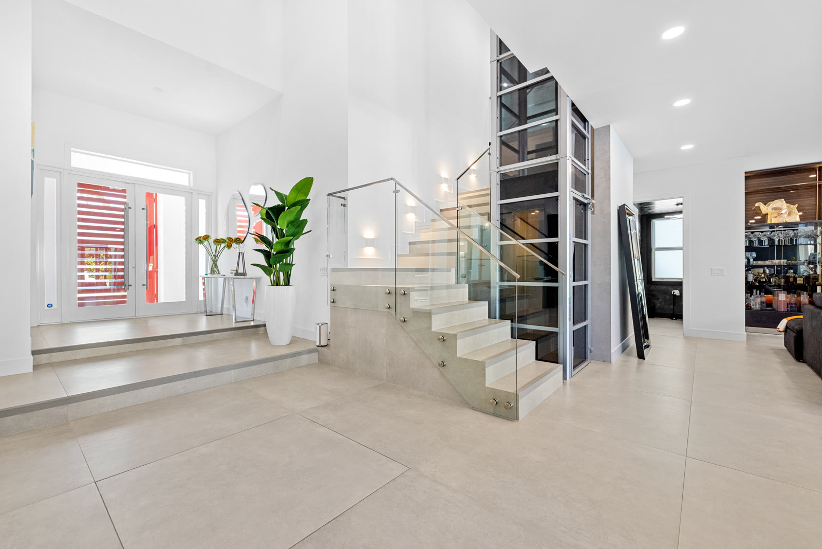 Glass staircase and elevator in the entryway of the Harbor Isle home, Boca Raton