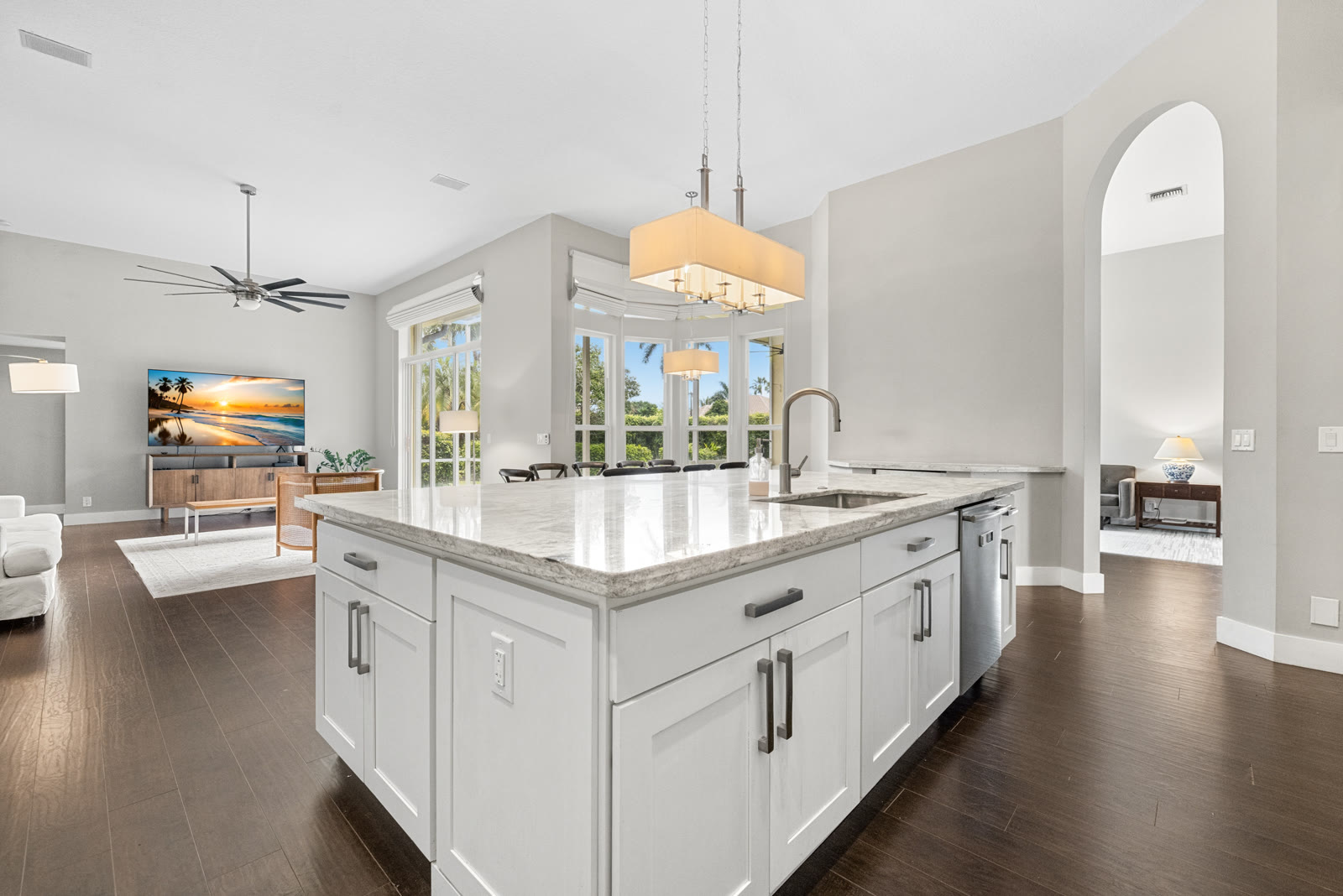 Bright white kitchen with waterfall island and pendant lighting in a Boca Raton home